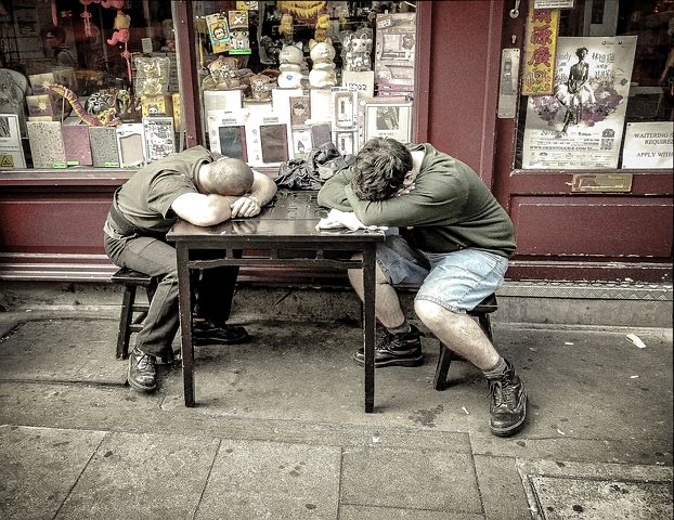 am Tisch schlafende Arbeiter