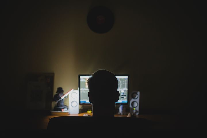 Mann sitzt nachts vor dem Monitor